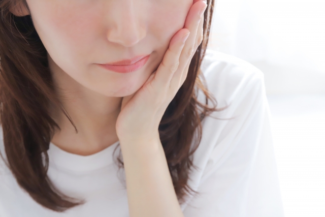 顔のむくみを気にしている女性